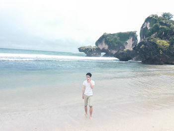 Full length rear view of man walking on beach