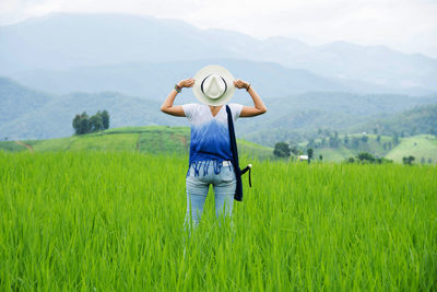 Rear view of a woman standing in field