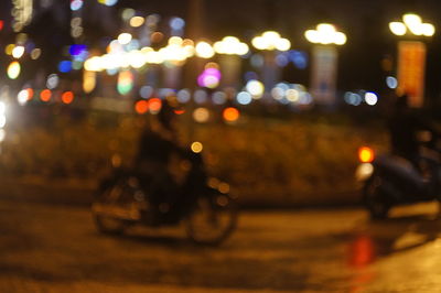 Defocused image of illuminated city on road at night