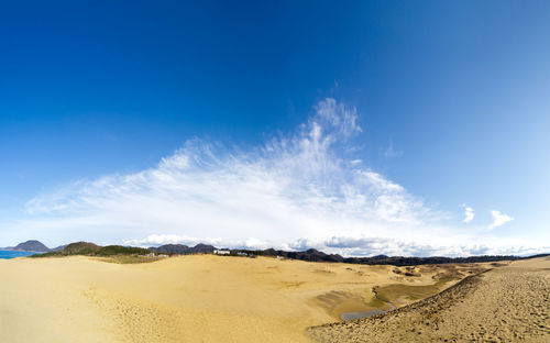 Panoramic view of desert against blue sky