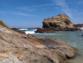 Scenic view of rocks on beach against sky