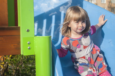 High angle view of girl sliding on slide at park