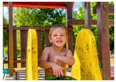 Portrait of smiling boy sitting at playground
