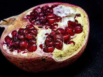 Close-up of strawberry in bowl against black background