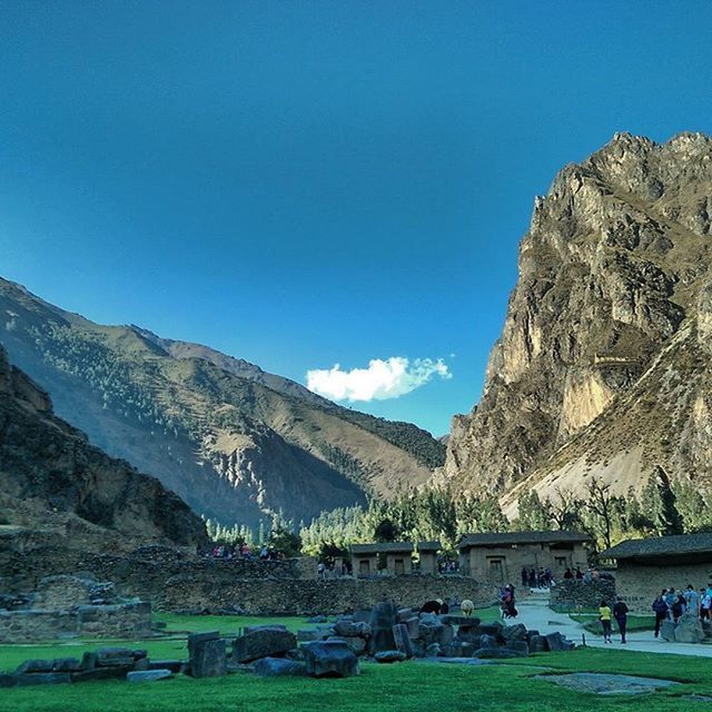 mountain, clear sky, blue, grass, built structure, landscape, architecture, building exterior, mountain range, sky, copy space, tree, tranquility, nature, beauty in nature, scenics, sunlight, tranquil scene, day, travel destinations