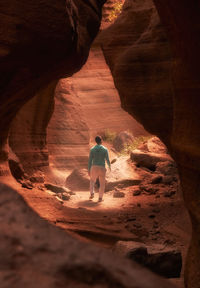 Rear view of man standing on rock