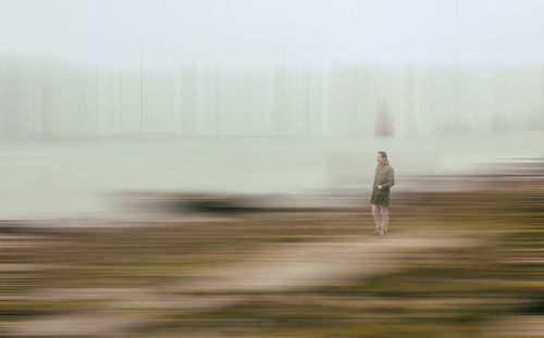 Digital composite image of man standing on road