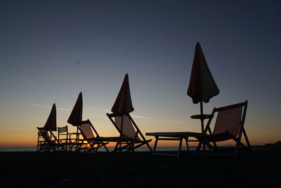 Lifeguard hut on beach against sky during sunset