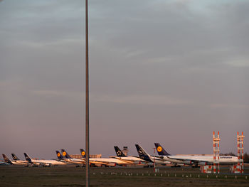 Airplane on airport runway against sky