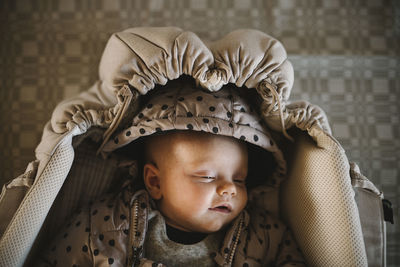 Newborn baby lying in stroller cot