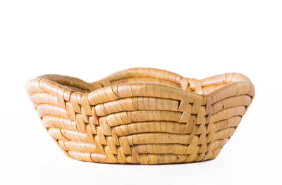 Close-up of heart shape on wicker basket against white background