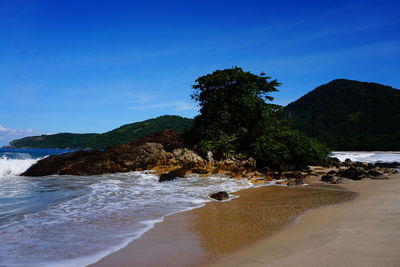 Scenic view of beach against blue sky