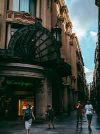 Rear view of people walking on building