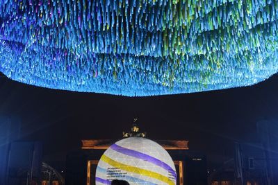 Low angle view of illuminated lights hanging from ceiling of building