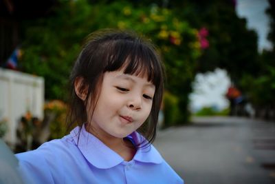 Close-up of girl making face while standing on road