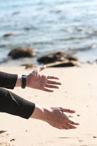 Midsection of person on sand at beach