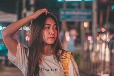 Portrait of young woman standing in city