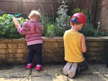 Rear view of siblings playing at park