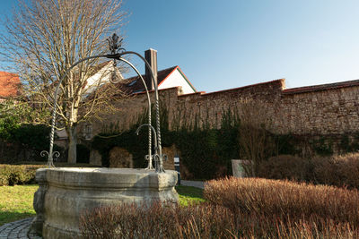 View of building by trees against clear sky