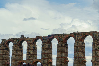 Arch bridge against cloudy sky