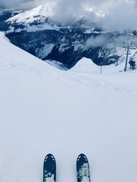 Low section of skis on snowcapped mountain