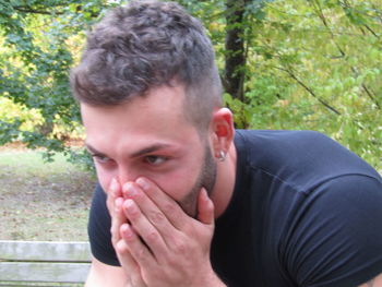 Portrait of young man against trees