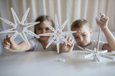 Cute sibling playing with toy at home