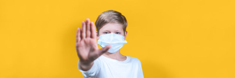 Portrait of boy holding yellow against orange background