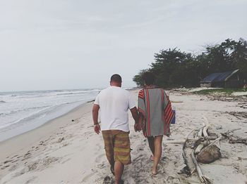 Rear view of people walking on beach