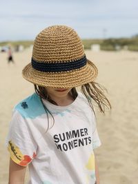 Portrait of woman wearing hat standing at beach