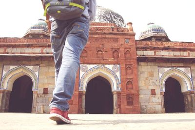 Low section of man standing by historic building