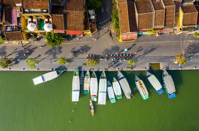 Drone view of boats in river by buildings