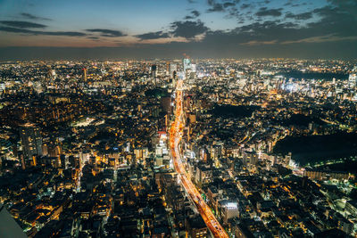 High angle view of illuminated cityscape against sky at night