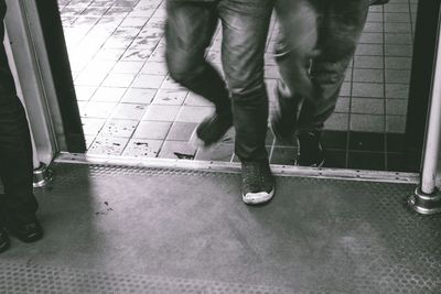 Low section of people standing on tiled floor