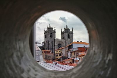 Buildings in city against cloudy sky