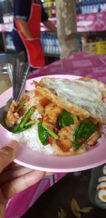 Close-up of hand holding food in plate