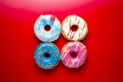 Directly above shot of multi colored candies against red background