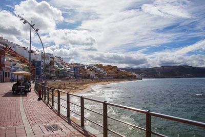 Scenic view of sea by city against sky