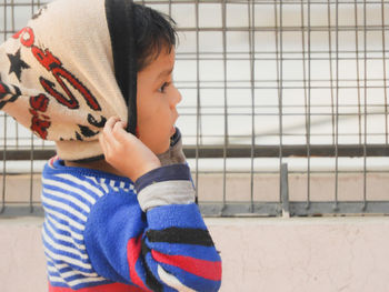 Side view of cute boy wearing knit hat while looking away outdoors