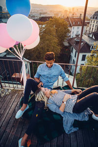 Couple sitting with wine by balloons