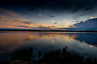 Scenic view of lake against sky at sunset