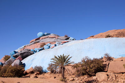 Built structure on rocky mountain against clear blue sky