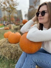 Portrait of young woman wearing sunglasses while sitting on field