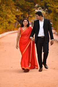 Young couple standing on footpath during autumn