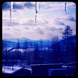 Scenic view of snow covered mountain against cloudy sky