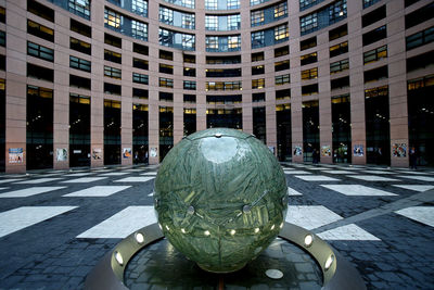 Close-up of sculpture on street against buildings