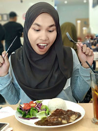 Midsection of woman holding ice cream in restaurant
