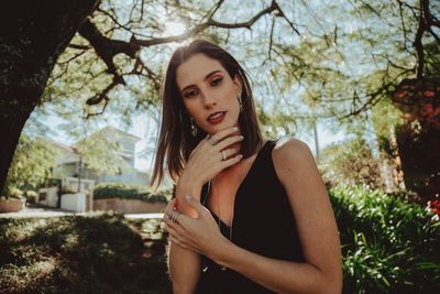 Portrait of beautiful woman against trees