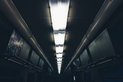 Low angle view of illuminated fluorescent lights in subway train