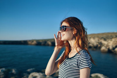 Portrait of mid adult man wearing sunglasses against sea